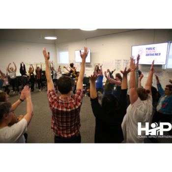 Participants from Public Health Awakened's first national organizing training in October 2019. Large group of people raising their hands in action.