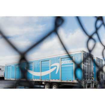 Photograph of an Amazon Prime storage unit through a chain link fence.